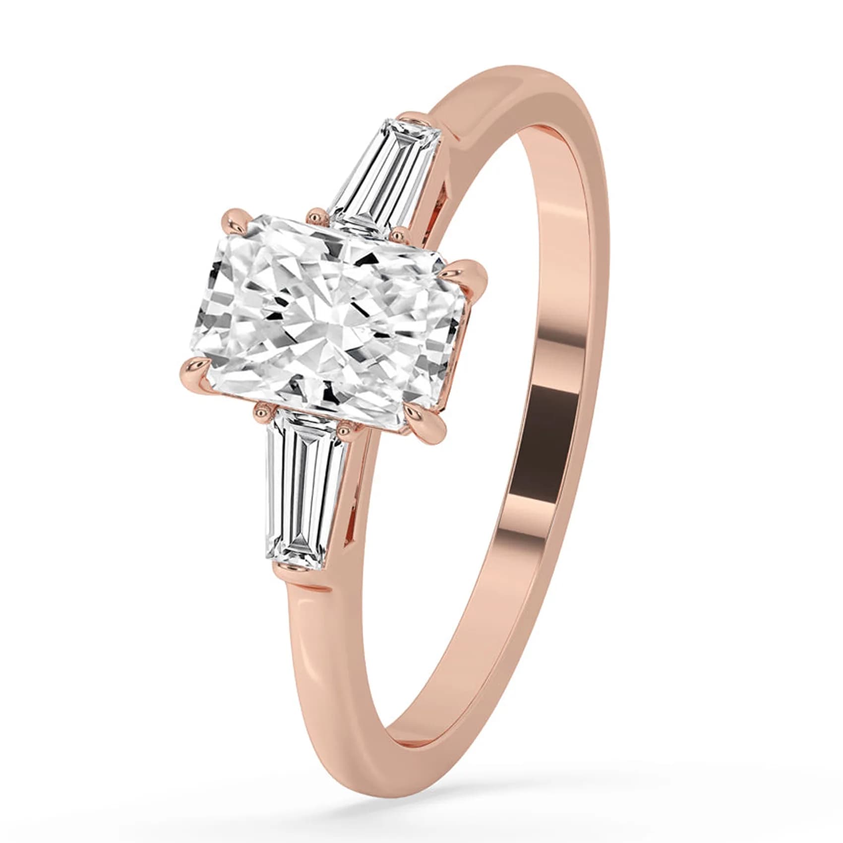 Angled view of the radiant cut three stone ring with tapered baguettes in rose gold